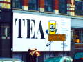 A big billboard on the side of a building with the word ‘Tea’ on it in capital letters.