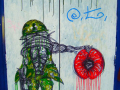 A graffiti of a scribbly drawn soldier holding a big poppy and above the soldier is written REMEMBER.