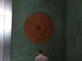 man looking at round artwork