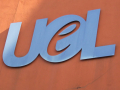 blue UEL logo on red wall