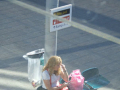 woman sitting at train station under Cyprus/UEL sign
