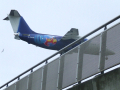 Plane flying over bridge